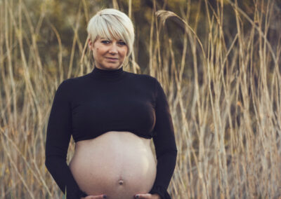 Gravid dame står i en kornmark
