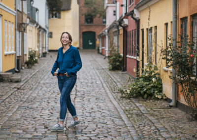braningbillede af Gitte Xenia taget i hc Andersen kvarteret i Odense. hun smiler og er afslappet og naturlig