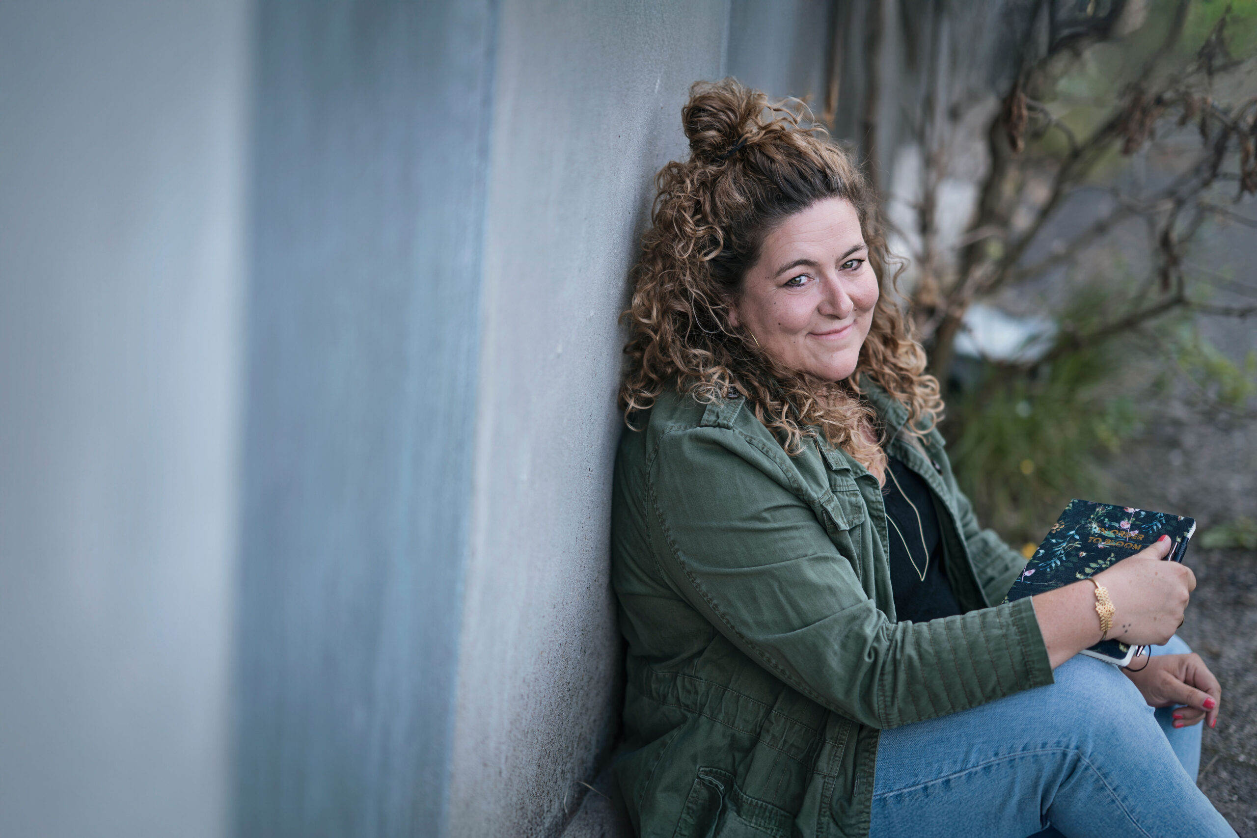 _DSC9362-copy billede af fotograf winnie synia. hun står på Odense havn, kigger til siden og smiler meget