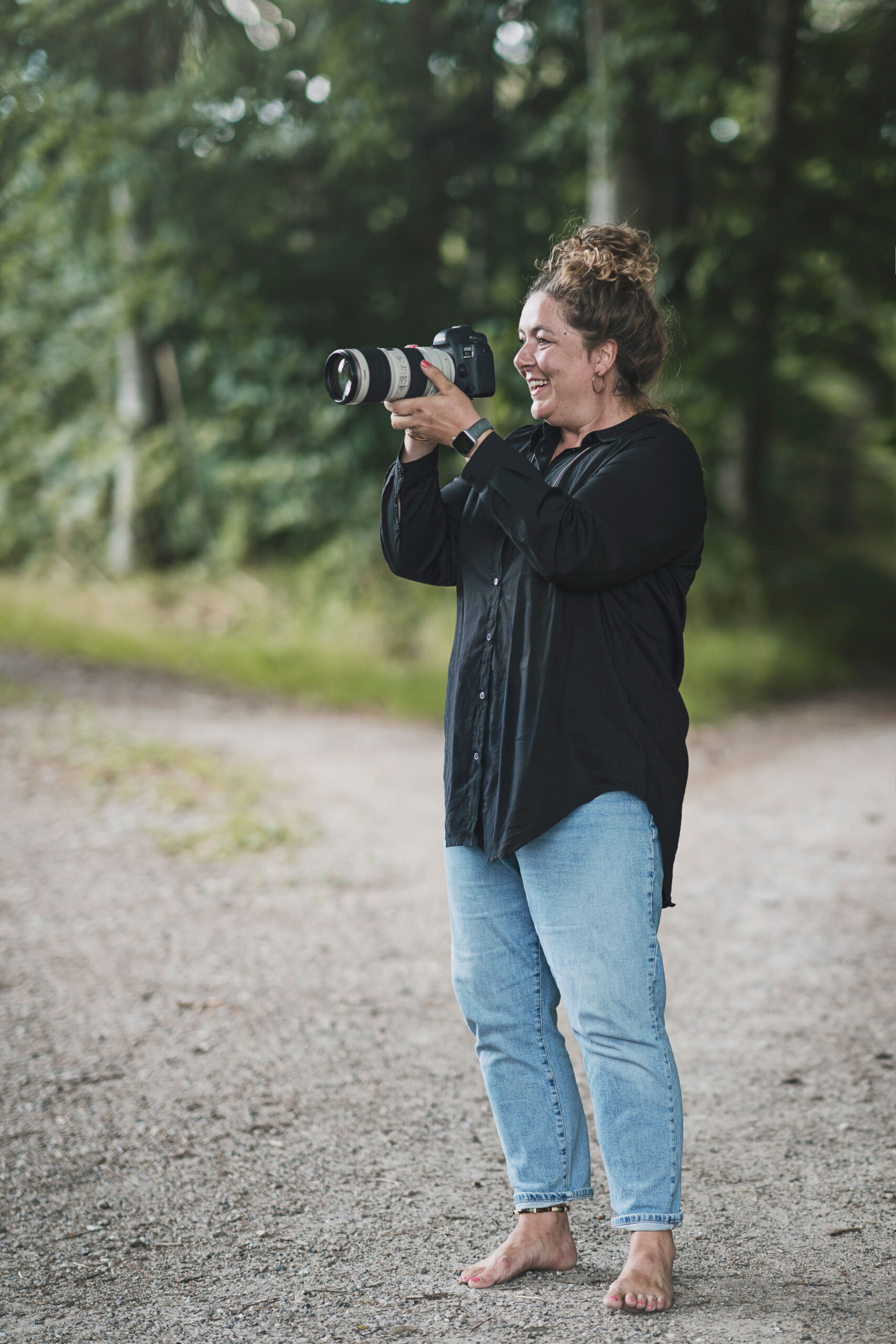 Portræt af fotograf winnie synia, fra Fyn. hun har briller på og en stribet cardigan, billedet er taget ved langesø på nordfyn