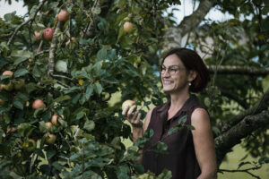Personligt brandingportræt af soloselvstændig kvinde i Horsens med æble i hånden hun arbejder med landbrug